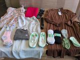 Plusieurs paires de chaussures et plusieurs vêtements sont disposés sur une table en bois