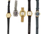 a group of four watches sitting next to each other on a white surface