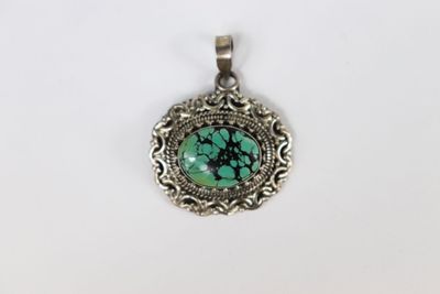 un pendentif en argent orné d'une pierre turquoise au centre