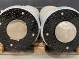 two metal pipes sitting on a pallet on the floor