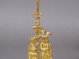 an image of a gold plated candle holder with a man and woman on it