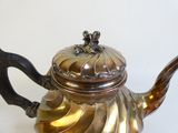 une théière en argent avec une anse sur une table