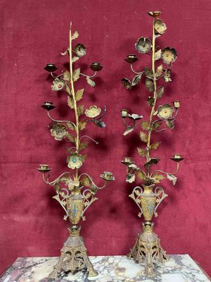 two vases with flowers are on a table with a red wall behind them