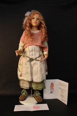an image of a doll is standing on a stand with a card