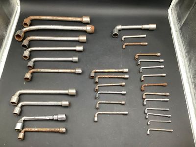 many wrenches in a metal tray on a table