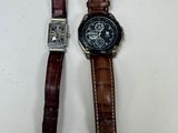 Deux montres sont posées l'une à côté de l'autre sur une surface blanche