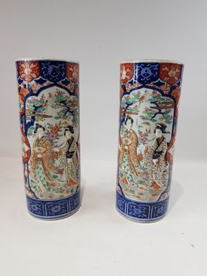 une paire de vases chinois posés sur une table blanche, sur fond blanc