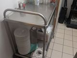 a metal cart with plates and cups on it in a kitchen