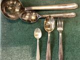 a spoon, fork, spoon and spoon rest on a green mat