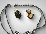 necklace and earring set with black and gold accents on a silver chain