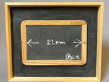 a blackboard with a wooden frame and a chalk board with an arrow pointing to the left