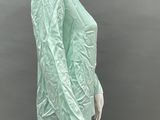 a mannequin wearing a green shirt and black pants