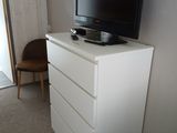 a white dresser with a television on top of it