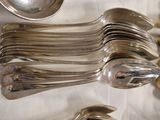 a lot of silver spoons and spoons sitting on a table