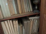 a book shelf with many books on it in the corner of a room