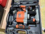 an orange and black electric drill in a case on a table