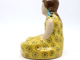 a figurine of a woman sitting on the ground