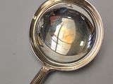 a silver spoon with a reflection of a person in it