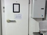 une porte blanche dans une pièce où se trouve une imprimante posée sur une table
