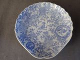 une assiette bleue et blanche ornée d'un motif floral