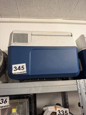 une glacière bleue posée sur une étagère dans un magasin