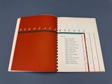 un livre ouvert, avec une couverture rouge, posé sur une surface bleue