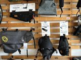 many bags and backpacks hanging on a wall in a store