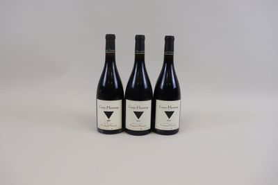 trois bouteilles de vin posées sur une table blanche