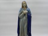 the statue of the virgin mary is standing on a white surface