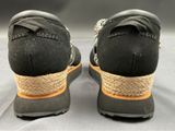 pair of black and orange shoes with a rope on top of them