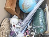 a cardboard box filled with assorted items including a baseball bat, a globe, and other items