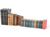 plusieurs vieux livres sont alignés sur une surface blanche
