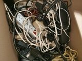 a cardboard box filled with a bunch of wires and remotes