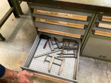 un homme en train d'ouvrir un tiroir contenant des outils