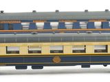 a blue and yellow train car sitting on a white surface