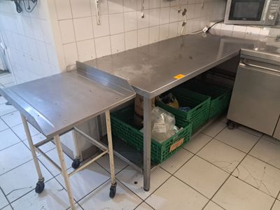 une cuisine avec une table en inox et un panier vert