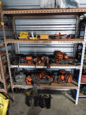 many different tools on the shelves in the garage