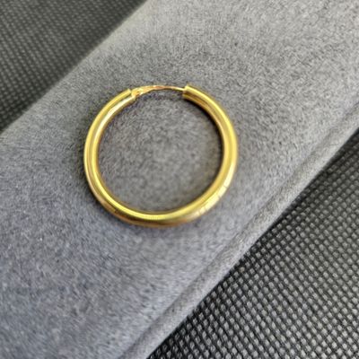 un gros plan d'une bague en or posée sur un tissu noir