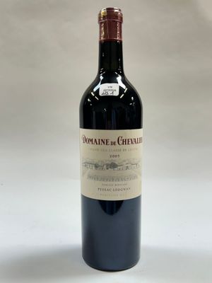une bouteille de vin posée sur une table blanche