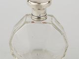 an image of a glass bottle with a silver lid on a white surface
