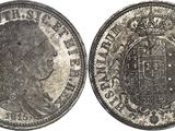 a close up of a silver coin with a crown on it