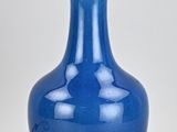 a blue vase with a black base and a white stripe on the top