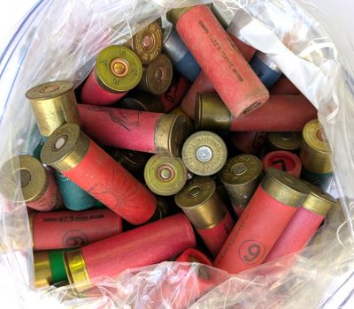 un sac en plastique rempli de cartouches de fusil de chasse posé sur une table