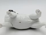 a figurine of a dog laying down on its back