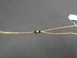 un bracelet en chaîne d'or orné d'une breloque en forme d'oiseau