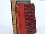 three books are stacked on top of each other on a table