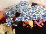 a pile of clothes that is laying on a bed