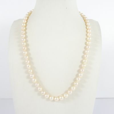 a white pearl necklace on a mannequin with a gold clasp