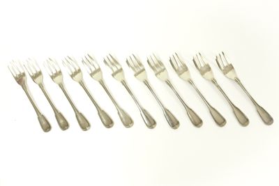 six fourchettes sont disposées en rangée sur une surface blanche