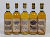 quatre bouteilles de vin posées les unes à côté des autres sur une surface blanche